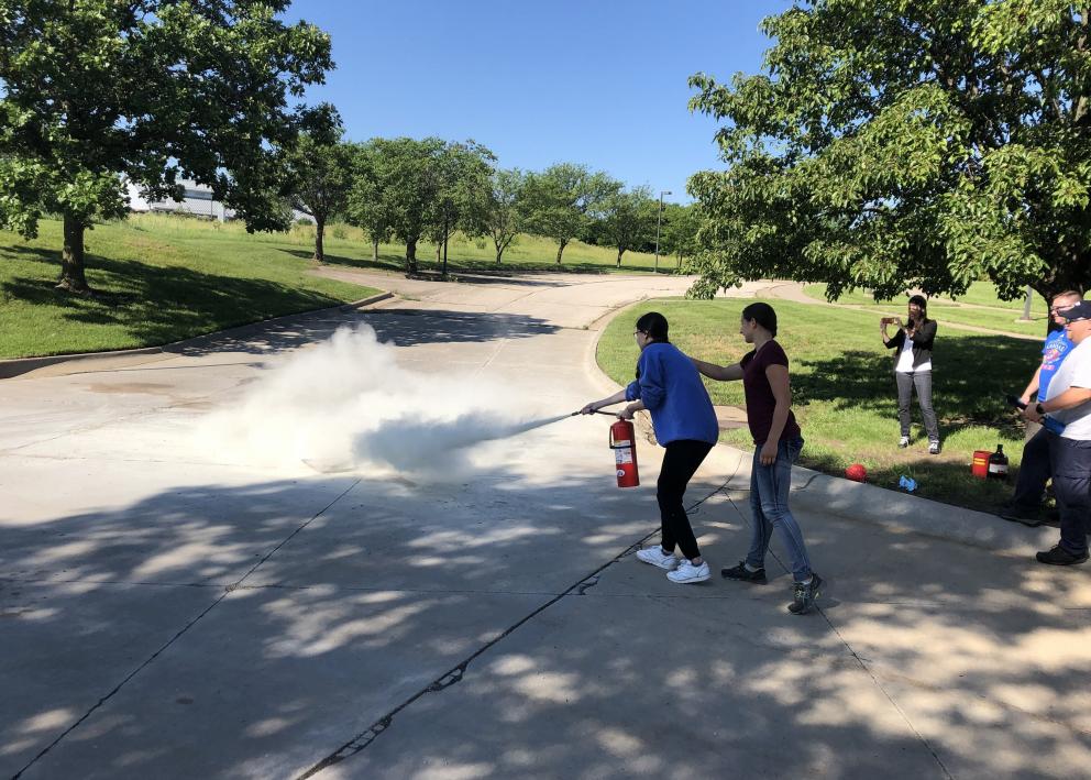 REU students Josephine Hriscu and Sierra Stratz during a safety training with fire extinguishers.