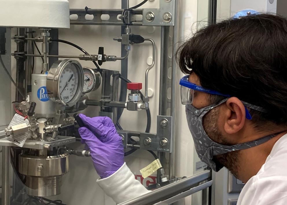 Post doc Carlos Castor adjusting a chemical reactor.